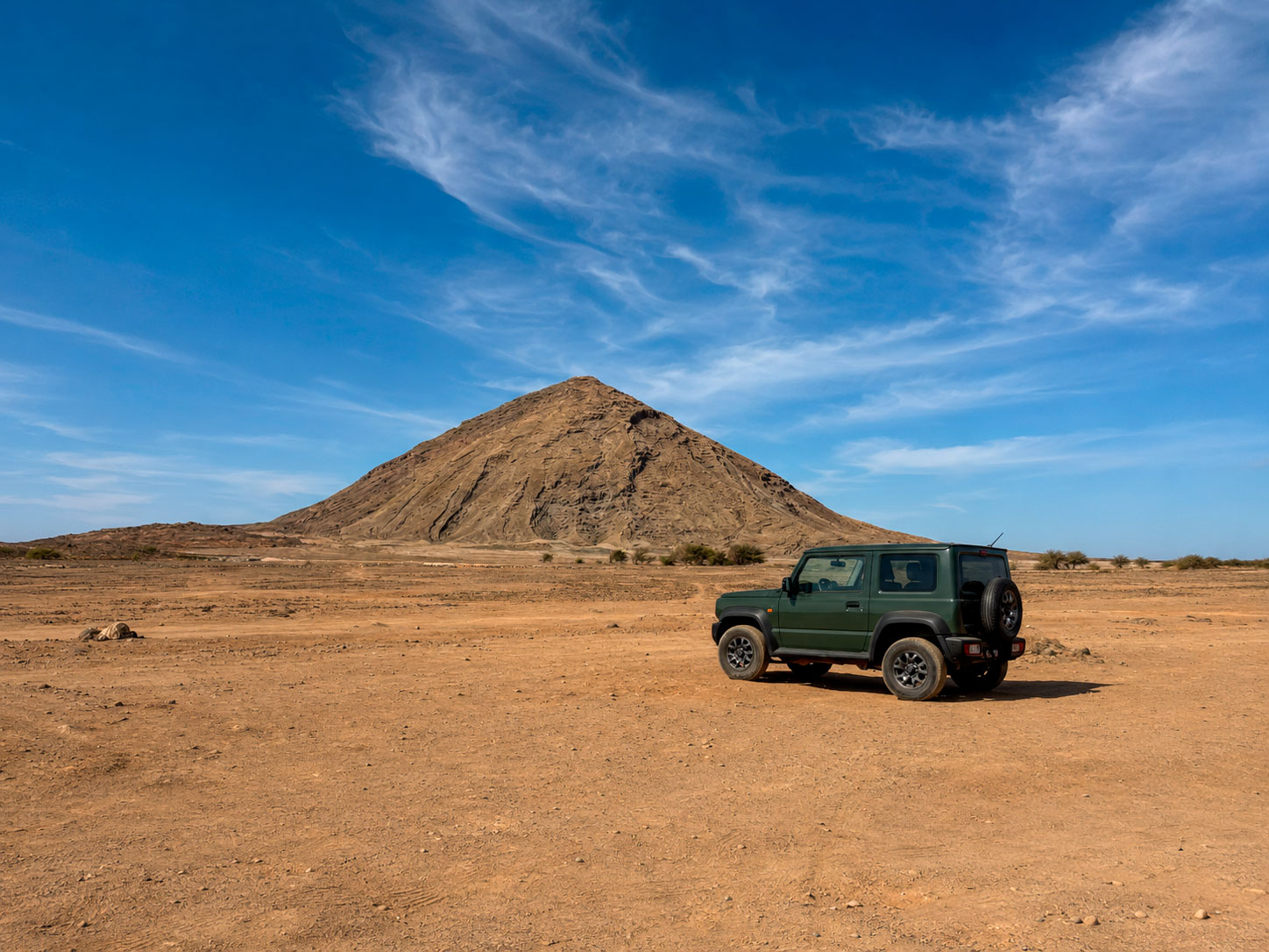 Rental Car Exploring Sal Island, Cape Verde Rental 4x4 parked beside a volcanic mountain in the arid landscape of Sal Island