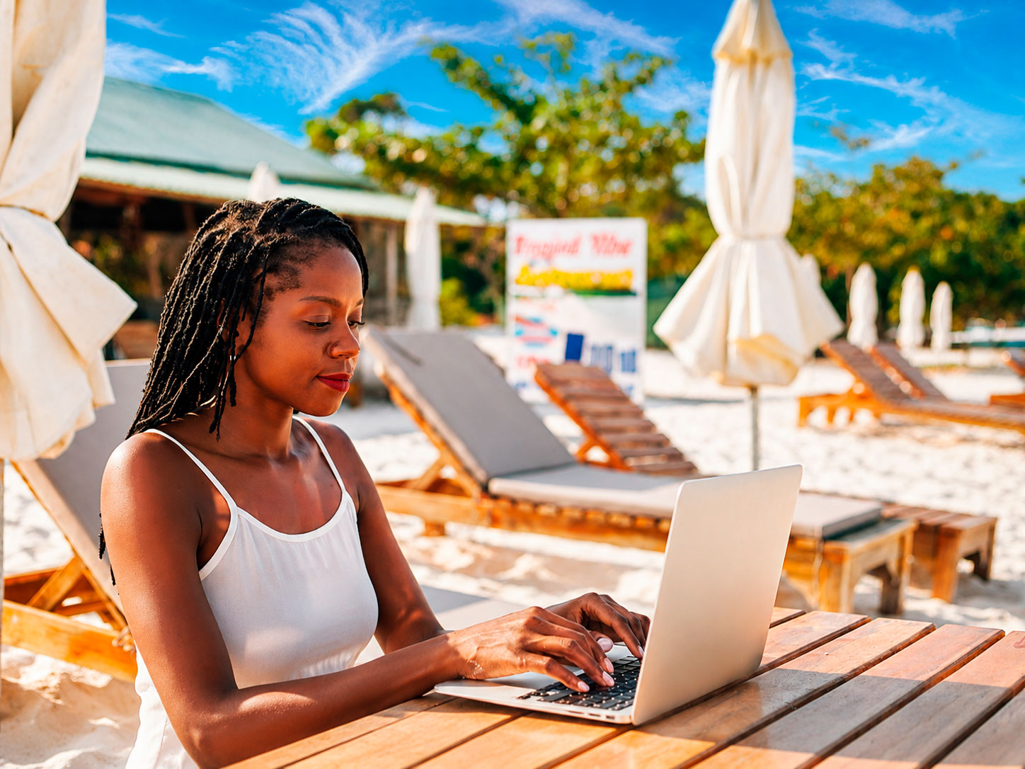 Internet and SIM Cards in Sal Island: What Travellers Need to Know Woman using a laptop at a beach resort in Sal Island, Cape Verde