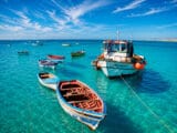 Colourful fishing boats anchored in the turquoise waters of Santa Maria, Sal Island